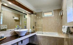 a bathroom with a sink and a bath tub at EVASION Bungalow Tropical Spa in Sarraméa