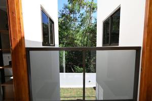 a view from the inside of a house with a window at Studio Céu Azul, Pontal de Maracaípe PE in Porto De Galinhas