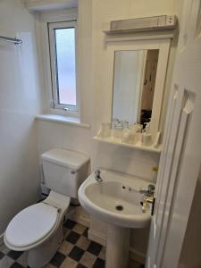a white bathroom with a toilet and a sink at Q Accommodation in Blackpool +70 photos