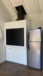 ein Kühlschrank in einem Zimmer mit einem Flachbildfernseher in der Unterkunft Casa Paraiso 1 - San Martin de los Andes in San Martín de los Andes + 19 Fotos
