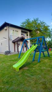 a playground with a slide in a yard at Sweet family home in Doglodi