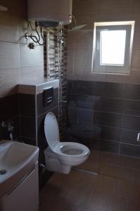 a bathroom with a toilet and a sink and a window at Sweet family home in Doglodi +43 photos