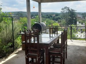 a wooden table and chairs on a balcony at ENCANTO SERRANO in Villa Carlos Paz
