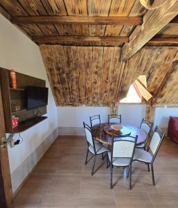a dining room with a wooden ceiling and a table and chairs at Chalé bom jardim in Ibicoara