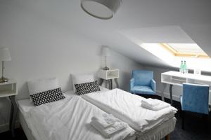 a bedroom with a bed and two blue chairs at Biała Wstążka B&B in Czepino