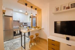 una cucina con un tavolo e una tv in una stanza di Oviedo Centro Apartastur26, en calle Gascona a Oviedo