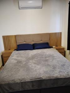 a bedroom with a bed with blue pillows on it at Casa Próximo a shopping Catuaí in Foz do Iguaçu +26 photos