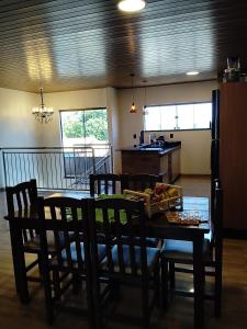a dining room with a table and chairs and a kitchen at Casa Próximo a shopping Catuaí in Foz do Iguaçu