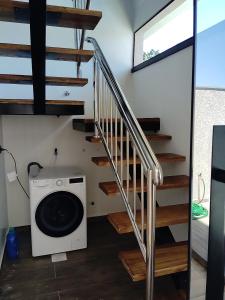 a laundry room with a washing machine and stairs at Casa Próximo a shopping Catuaí in Foz do Iguaçu