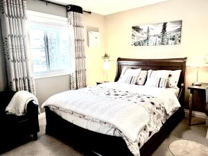 Un dormitorio con una cama grande y una ventana en Cozy Walkout suite with King bed, Kitchen, Parking & Patio, en Calgary
