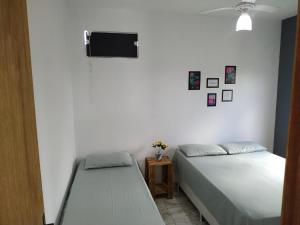 カボ・フリオにあるFlat Solife 1 Cabo Frio-Búziosのベッドが2つと壁にテレビがある寝室