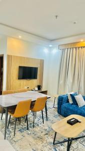 a living room with a table and a blue couch at شقق اليمامة المميز الفندقية ينبع in Yanbu +20 photos