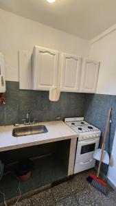 a kitchen with a sink and a stove at Alquiler de departamento en Santa Teresita in Santa Teresita