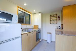 a kitchen with a white refrigerator and a sink at Kundaniwas in Rotorua