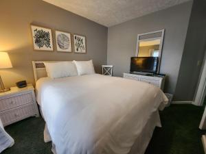 a bedroom with a large white bed and a television at North Shore Inn TC 205 in Traverse City +12 photos