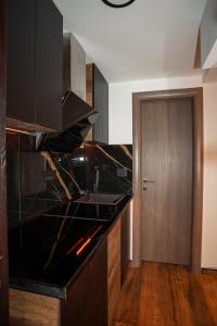 科帕奥尼克KonKal - Royal resort的厨房铺有木地板,配有黑色台面