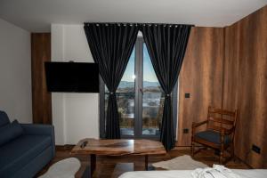 科帕奥尼克KonKal - Royal resort的客厅里有一张沙发、一张桌子和一扇窗户