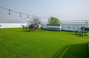阿克拉Aster Luxury Apt close to Airport & Mall with Rooftop pool & gym的绿色草坪上带桌椅的庭院