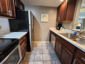 a kitchen with wooden cabinets and a stainless steel refrigerator at North Shore Inn TC 103 in Traverse City
