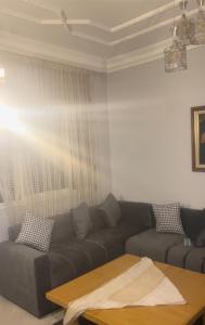 ein Wohnzimmer mit Sofa und Tisch in der Unterkunft Studio en plein centre de Hassan Rabat in Rabat