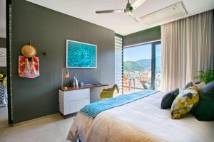 a bedroom with a large bed and a large window at HGTV Loft | Rooftop Pool + Gym + Views + Bar in Puerto Vallarta +29 photos