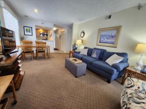 a living room with a blue couch and a dining room at North Shore Inn TC 106 in Traverse City