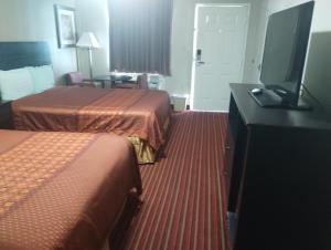 a hotel room with two beds and a flat screen tv at Deer Field Inn in Osceola