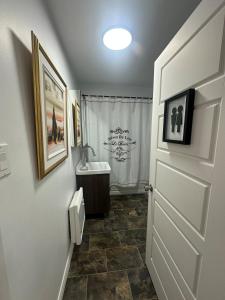 ein Bad mit einem Waschbecken, einem WC und einer Tür in der Unterkunft 20 Minutes de Montréal, 1 chambre et 2 lits pour maximum 4 personnes in Pointe-Calumet + 27 Fotos