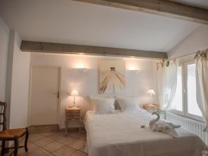 a bedroom with a white bed with a bird on it at La Sarrazine in Les Mées +39 photos