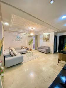 a living room with two couches and a chandelier at Appartement de lux in Casablanca