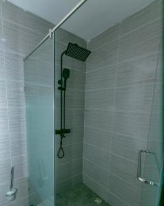 阿克拉Aster Luxury Apt close to Airport & Mall with Rooftop pool & gym的浴室里有玻璃门的淋浴间