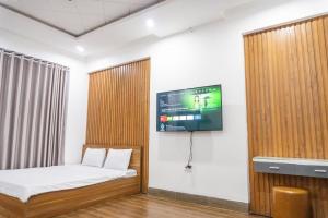 a room with a bed and a tv on a wall at Cherry homestay bmt phòng đôi gia đình in Buôn Ðũng +4 photos
