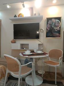 a living room with a table and chairs and a tv at Miranda's Suite by Fullerton in Silang +13 photos