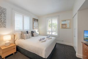 En eller flere senge i et værelse på Chic Hastings Street Apartment + 9 billeder