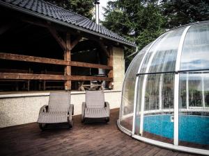 two chairs and a glass dome next to a swimming pool at Villa in Staré Hamry near Ski Park Grun in Staré Hamry