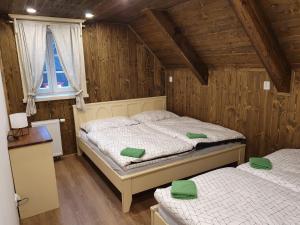 due letti in una stanza con pareti in legno di Villa in Cerna Hora near Ski Slopes a Horní Maršov