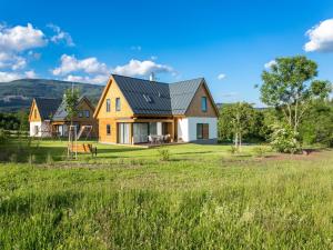 a house with a metal roof on a green field at Chalet in istá near Ski Slopes in Cerny Dul