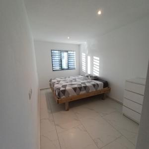 a bedroom with a bed in a white room at Flamingo Apartment - Regal Rentals Curacao in Willemstad