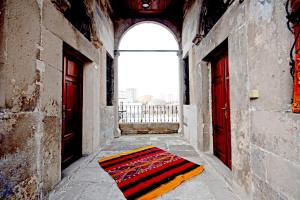 a rug on the floor in a hallway with two red doors at Setenonu 1892 Hotel in Kayseri