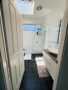 un baño con lavabo y espejo en House at the Heart of Entrance! Sleeps20, en The Entrance