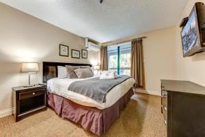 Un dormitorio con una cama grande y un televisor. en Greystone Lodge 408 Luxury, en Whistler