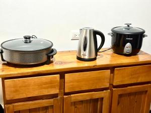 a slow cooker and a pot on top of a wooden cabinet at Apartamento Chazu #3 in Quepos