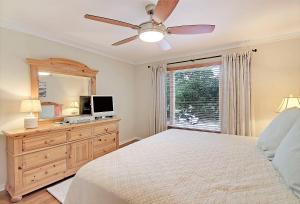 a bedroom with a bed and a dresser with a television at SG6A: 6A Seagrove Villa in Isle of Palms +20 photos