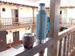 a water bottle and a pot on a wooden railing at Hotel Casa Fierro Cusco in Cusco