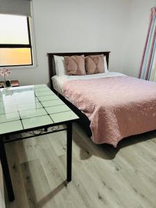 a bedroom with a bed and a glass table at Easy check in in Rotorua +6 photos
