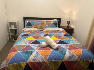 a colorful bed with two stuffed animals on it at Easy check in in Rotorua