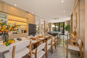 ein Esszimmer mit einem Billardtisch und Stühlen in der Unterkunft Sense Pool Villa - Luxurious 500m2 Pool Mansion Walk to My Khe Beach in Đà Nẵng