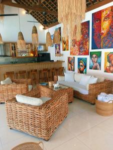 a restaurant with wicker seating and paintings on the wall at Villa Dunia - 400M Private Villa Walk to Beach Top location Gili Trawangan in Gili Trawangan