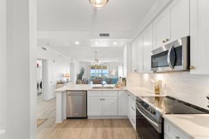 a white kitchen with a sink and a stove at Beach Colony West 1C in Pensacola