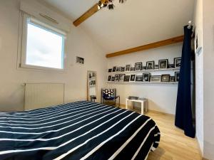 a bedroom with a blue and white striped bed at Chambre cosy avec terrasse et jardin proche Puy-en-Velay - FR-1-582-526 in Saint-Germain-Laprade